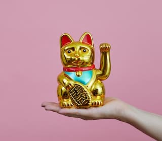 手のひらに乗せた金色の招き猫